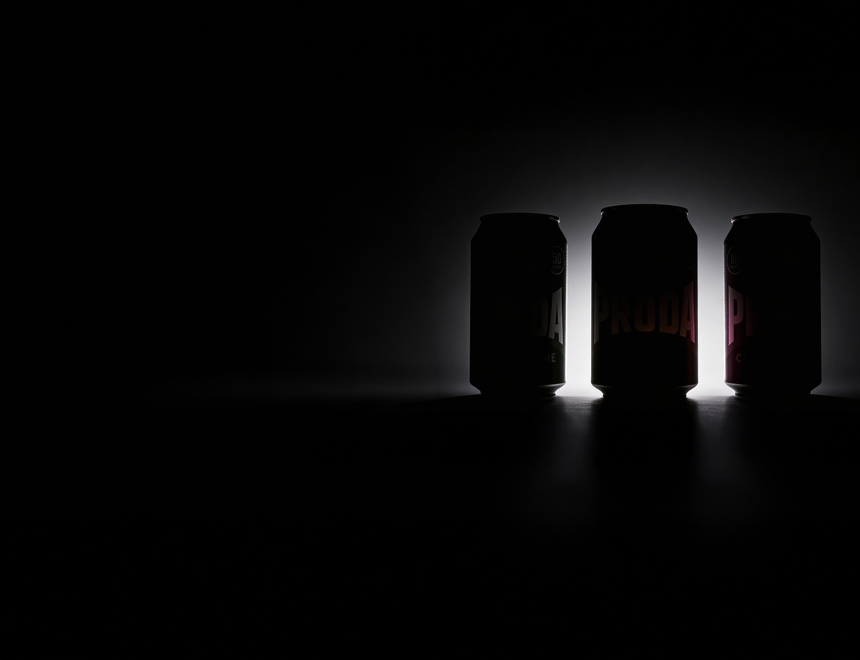 Proda Cans with dark background and light coming from behind