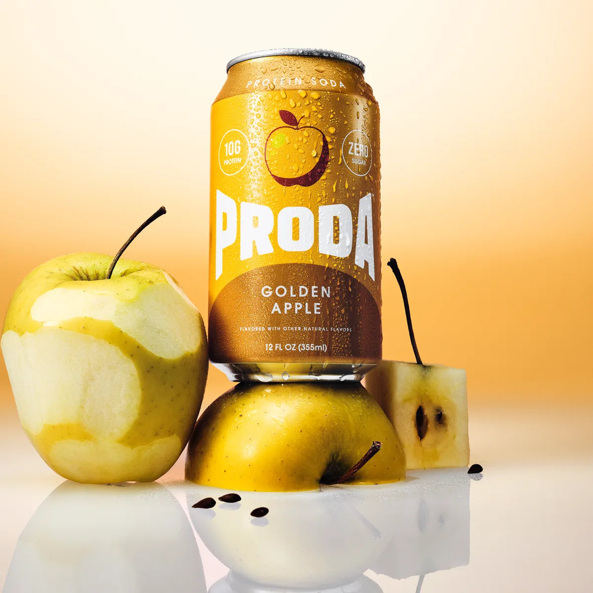 A can of PRODA Golden Apple on golden apples, one of them peeled, on a warm yellow backdrop