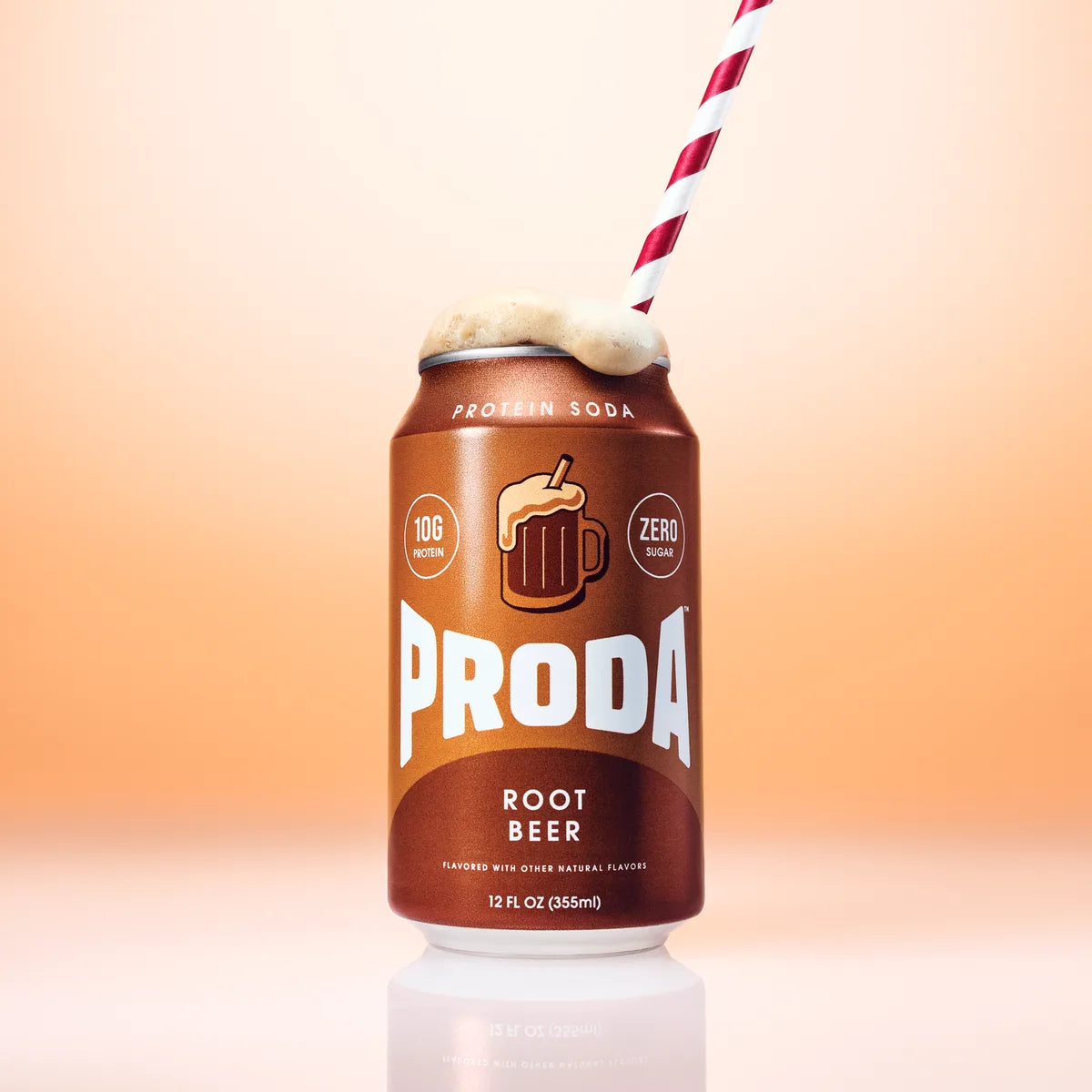 A can of PRODA Root Beer topped with foam and a striped straw on a peach backdrop