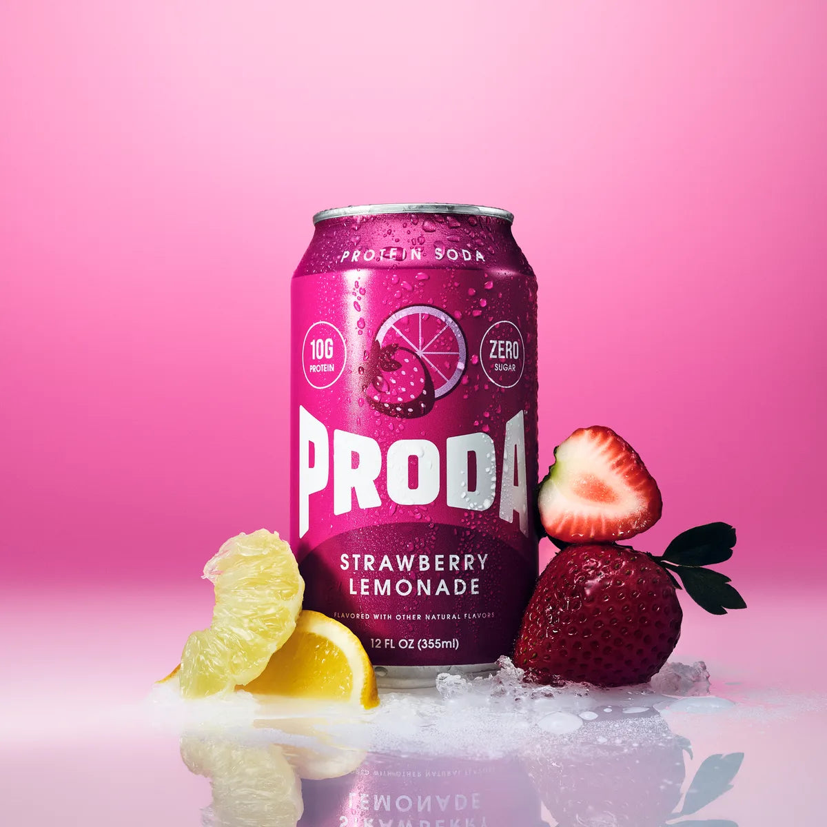 A can of PRODA Strawberry Lemonade with strawberries and lemon wedges on a pink backdrop